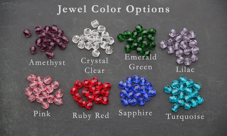 May include: Assortment of jewel tones in crystal beads, including amethyst, crystal clear, emerald green, lilac, pink, ruby red, sapphire, and turquoise.