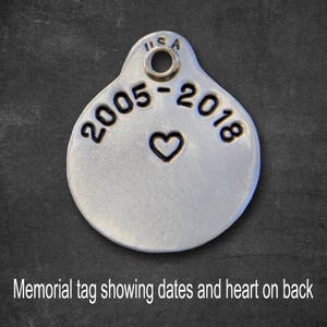 May include: Silver memorial tag with the dates "2005-2018" and a heart engraved on the back.