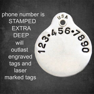 May include: A silver round pet tag with a stamped phone number, "123.456.7890", and the text "USA". The tag is designed to outlast engraved and laser-marked tags.