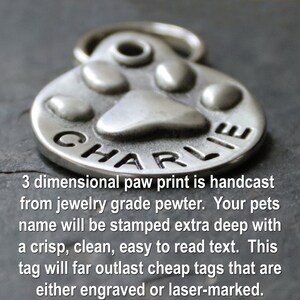 May include: Silver paw print pet ID tag with the name "CHARLIE" engraved on it. The tag is 3-dimensional and hand cast from jewellery grade pewter.