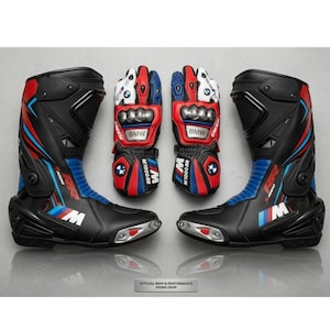 Puede incluir: Un conjunto de botas y guantes de moto negros y rojos. Las botas y guantes presentan detalles azules y blancos, con el logotipo de BMW. Diseñados para la práctica del motociclismo.