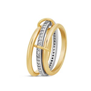 May include: A gold-tone ring with three interlocking bands. One band is silver-tone and encrusted with small, clear gemstones. The other two bands are smooth and gold-tone. The ring has a unique, modern design.
