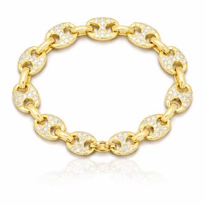 May include: A gold-colored bracelet featuring a series of oval links, each encrusted with small, sparkling stones. The bracelet has a polished finish and a secure clasp. The design is elegant and suitable for various occasions.