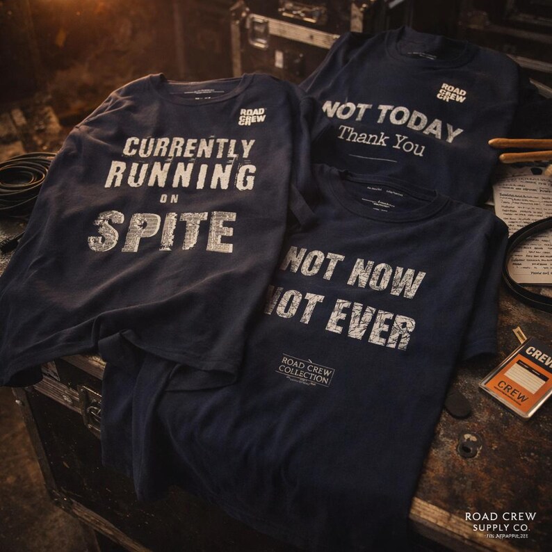 Puede incluir: Tres camisetas azul marino con texto blanco. Una dice "CURRENTLY RUNNING ON SPITE", otra "NOT TODAY Thank You", y la tercera "NOT NOW NOT EVER". Las camisetas son de la colecci&oacute;n Road Crew.