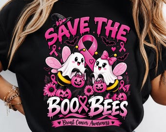 Puede incluir: Una camiseta negra con un gráfico de dos abejas fantasma, lazos rosas de concienciación sobre el cáncer de mama, calabazas y murciélagos. El texto "SAVE THE BOO BEES" y "Breast Cancer Awareness" aparece en letras rosas con efecto goteo.