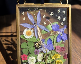 ドライフラワーが入った小さな金色の吊り下げフレーム