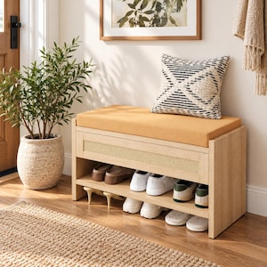 May include: A light wood shoe storage bench featuring a mustard yellow upholstered seat cushion and a woven cane front panel. The bench includes two open shelves holding various pairs of sneakers, loafers, and slippers.