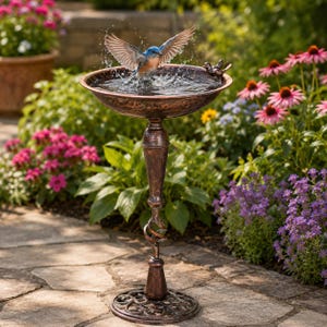 May include: A copper-colored birdbath with a wide basin, a twisted pedestal, and a decorative base. A small blue bird is splashing in the water within the basin, and a small metal bird figurine is attached to the rim of the basin.
