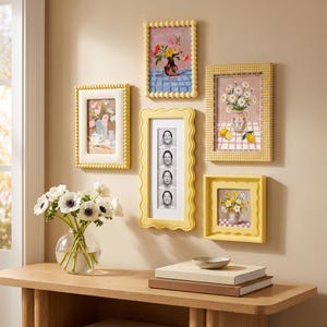May include: A gallery wall arrangement featuring five yellow frames of varying shapes and textures. The frames contain floral paintings, a checkered pattern, and a vertical strip of four black and white portraits of the same person.