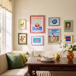 May include: A gallery wall featuring seven framed prints with scalloped or beaded edges. The art includes an Old Fashioned cocktail, a tomato illustration labeled Pomodoro, a sardine tin, a BFF horse graphic, and a portrait of a person.