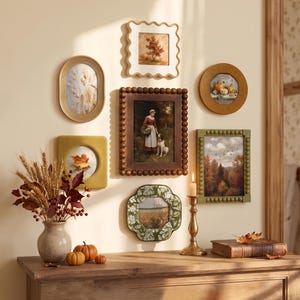 Könnte beinhalten: Eine Galeriewand mit sechs verschiedenen Bilderrahmen in unterschiedlichen Formen und Texturen, darunter ovale, gewellte und perlenbesetzte Designs, die herbstliche Kunstdrucke zeigen und über einem Holzkonsolentisch hängen.