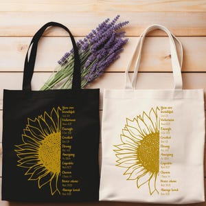 May include: Two tote bags, one black and one off-white, each featuring a large yellow sunflower design. Text on the bags reads "You are beautiful, victorious, enough, created, strong, amazing, capable, chosen, never alone, always loved."