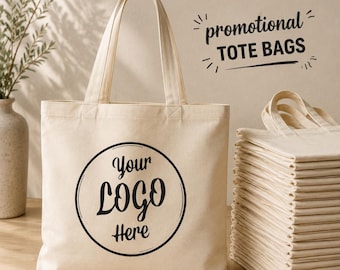 May include: A beige canvas tote bag with two handles and a black circular graphic containing the text Your LOGO Here. To the right, a stack of identical folded tote bags is visible. Above the bags, the text promotional TOTE BAGS is printed.
