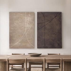 May include: Two rectangular wall art canvases displayed side by side. The left canvas is a light beige with thin, intersecting white lines. The right canvas is a dark charcoal gray with thin, intersecting black lines. Both feature a textured finish.