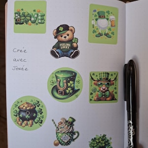 Puede incluir: Una página de cuaderno con varias pegatinas con temática del Día de San Patricio. Las pegatinas incluyen un oso de peluche, una pelota de golf, una olla de oro, un sombrero de duende, un toro, una taza de café, un sombrero lleno de tréboles y la palabra "LOVE" con tréboles.