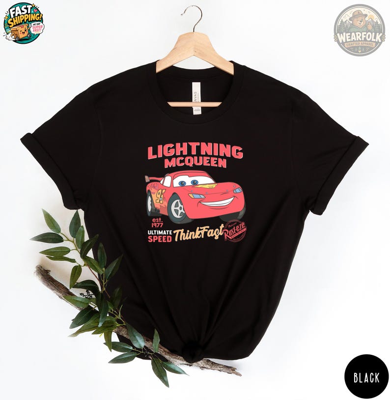 Black Bella Canvas tee with a red Lightning McQueen race car graphic and text reading "Lightning McQueen est. 1977 Ultimate Speed Think Fast Radiator.