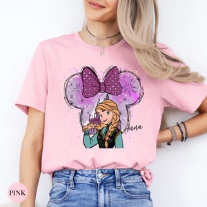 A woman wearing a pink tee with Anna from Frozen inside a purple polka dot bow with sparkles and the name "Anna" in script text.