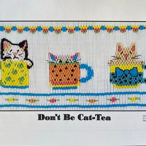 May include: A cross-stitch pattern featuring three cats in teacups. The cats are wearing different outfits and have different expressions. The pattern is titled "Don't Be Cat-Tea" and is copyrighted by Crossed Cricket, 2021.  Plate #323.