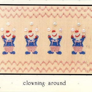 May include: A cross-stitch pattern featuring four clowns juggling balls. The clowns are wearing blue and red costumes with white accents. The pattern is on a light peach background with a red and pink zig-zag border. The text "clowning around" is printed below the pattern.