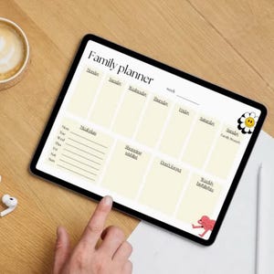 May include: A digital family planner displayed on a tablet, featuring sections for each day of the week, meal plans, and reminders. A cup of coffee and wireless earbuds are next to the tablet on a wooden surface.