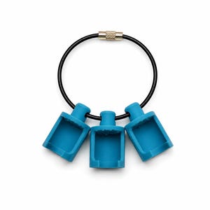 May include: A black circular cable ring with a metallic screw closure, featuring three bright blue silicone holders attached to the wire. Each holder has a rectangular opening and a cylindrical top, arranged symmetrically along the black cable.