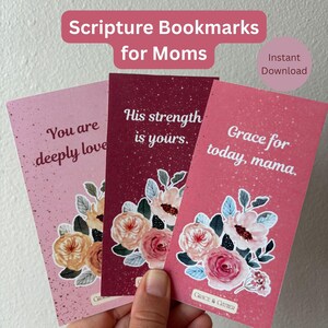 May include: Three scripture bookmarks for moms with floral designs and inspirational quotes. The bookmarks are in shades of pink and burgundy. The text on the bookmarks includes "You are deeply loved," "His strength is yours," and "Grace for today, mama."