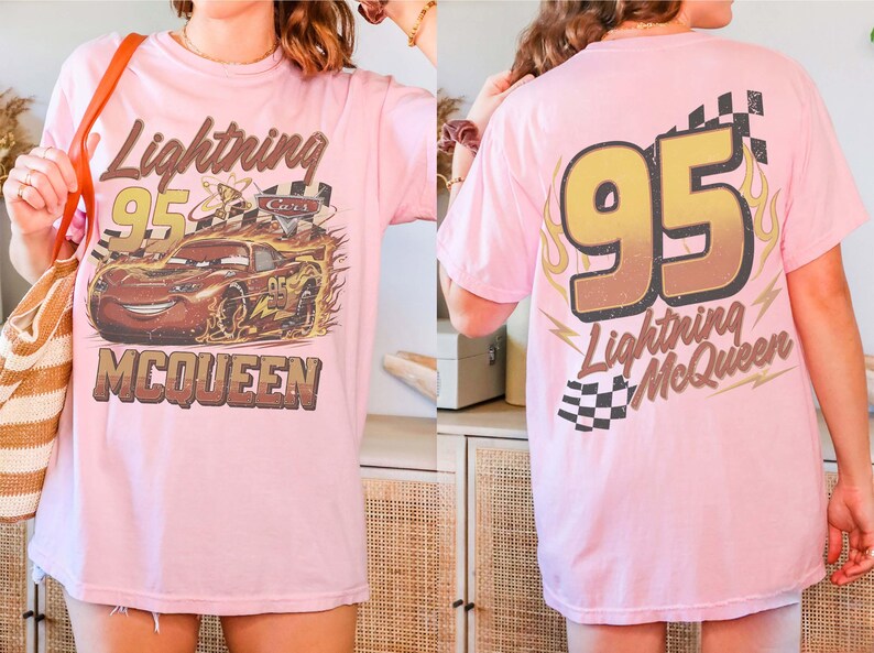 Puede incluir: Camiseta rosa claro con un gr&aacute;fico desgastado del coche de carreras Lightning McQueen, el n&uacute;mero 95 y el texto "Lightning McQueen". La parte trasera de la camiseta tambi&eacute;n muestra el n&uacute;mero 95 y el texto "Lightning McQueen".