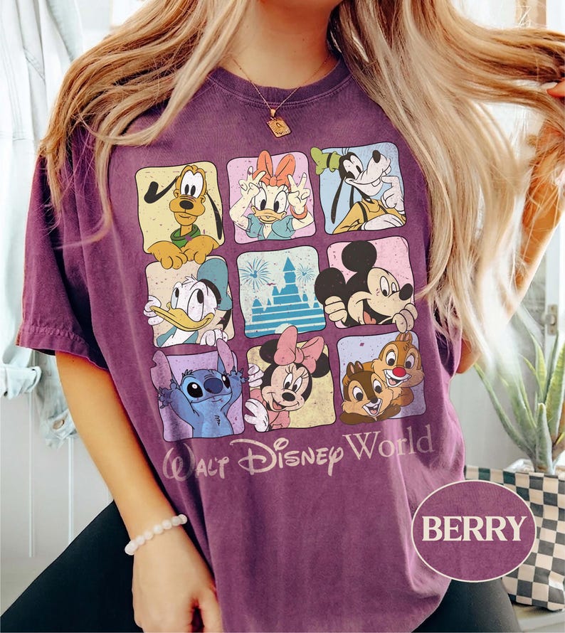 May include: Berry-colored t-shirt featuring a grid of Disney characters including Mickey Mouse, Donald Duck, and Stitch. The shirt has the words "Walt Disney World" printed below the grid. The shirt is a short-sleeved crew neck.