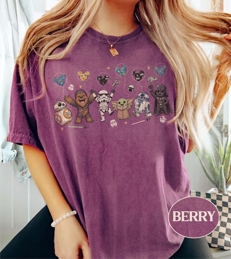 May include: Berry-colored t-shirt featuring a Star Wars character design. The graphic includes BB-8, Chewbacca, a Stormtrooper, Grogu, R2-D2, and Darth Vader, each holding a balloon. The word "BERRY" is printed on the bottom right.