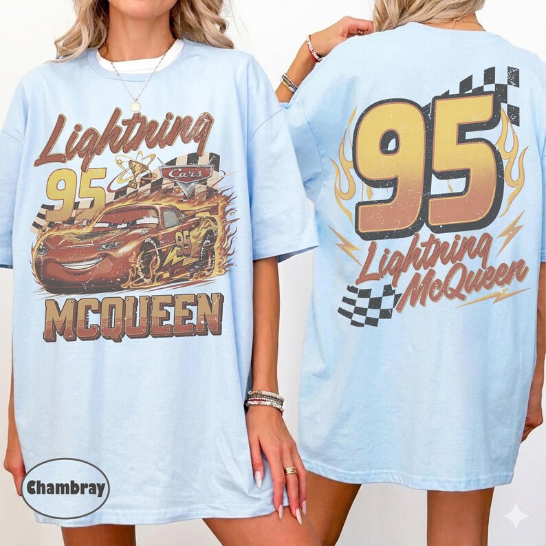 Puede incluir: Camiseta azul claro con Lightning McQueen de la pel&iacute;cula Cars. El frente muestra a McQueen con llamas y el n&uacute;mero 95. La parte posterior muestra un gran 95 con llamas y las palabras "Lightning McQueen" y una bandera a cuadros.