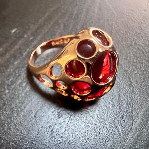 14K RG rullad guldring med öppen urring, oval rubinröd simulerad sten, storlek 7