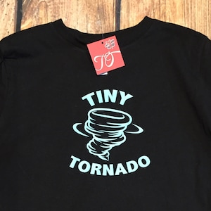 May include: Black t-shirt with a blue graphic of a tornado and the text "Tiny Tornado".