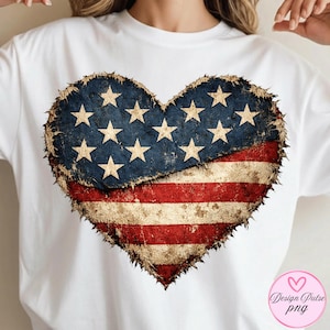 May include: White t-shirt featuring a distressed heart design in the colors of the American flag. The heart has a blue section with white stars and a red and white striped section.