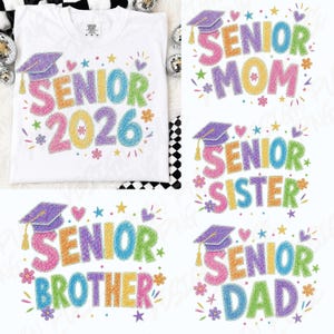 May include: White t-shirts with colourful "Senior" designs, including "2026", "Mom", "Sister", "Brother", and "Dad". Each design features a graduation cap, flowers, and stars. The shirts are decorated with a crayon-like texture.