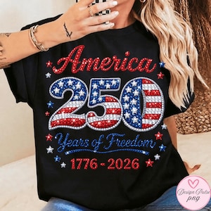 Puede incluir: Camiseta negra con un dise&ntilde;o patri&oacute;tico que celebra el 250 aniversario de Am&eacute;rica. El dise&ntilde;o presenta la palabra "America" en rojo, el n&uacute;mero "250" con acentos rojos, blancos y azules, y el texto "Years of Freedom 1776-2026."