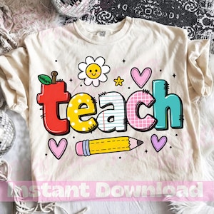 Op de afbeelding: Crèmekleurig T-shirt met het woord "teach" in kleurrijke, cartoonachtige letters. Het ontwerp bevat een appel, madeliefje, harten en een potlood. Een leuke, back-to-school thema grafisch t-shirt.