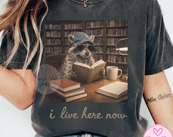 Rolig tvättbjörn som läser PNG, jag bor här nu-tröjadesign, bokälskare-tvättbjörn, biblioteksestetik, nördig djurclipart, mysig läsning DTG-design