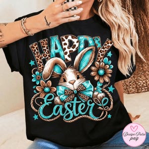 May include: Black t-shirt with a colorful Easter design. The design features the words "HAPPY EASTER" with a bunny, flowers, and stars. The bunny has blue and leopard print accents. The flowers are brown and blue.