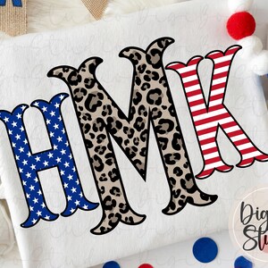 May include: White t-shirt featuring the letters HMK in a patriotic design. The letter H is blue with white stars, M is leopard print, and K is red and white stripes. The DigiBo Studio logo is in the bottom right corner.
