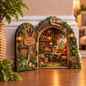 May include: A decorative arched wall display featuring a dinosaur theme with an open door labeled DINOSAUR WORLD. The interior shows a miniature library with a reading dinosaur, shelves of books, a globe, and a view of a volcano through a window.