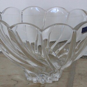 May include: A clear glass bowl with a swirling design. The bowl has a scalloped edge and a label that reads "Made in Czechoslovakia".