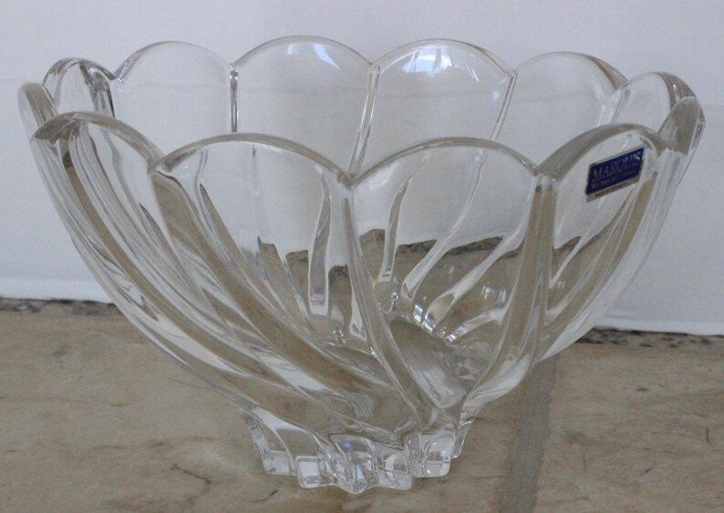 May include: A clear glass bowl with a swirling design. The bowl has a scalloped edge and a label that reads "Made in Czechoslovakia".