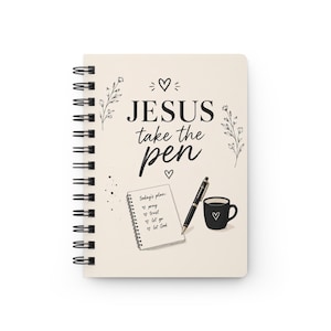 May include: A spiral-bound notebook with a cream cover featuring black text that reads JESUS take the pen, surrounded by floral line art and hearts. Below, an illustration shows a small notepad with a to-do list, a black pen, and a black mug.