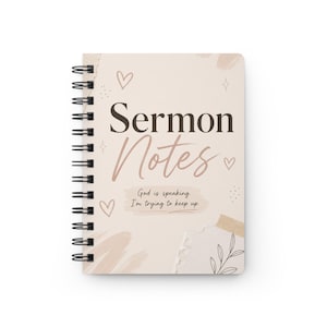 以下が含まれることがあります： 「Sermon Notes」の文字がスタイリッシュなフォントで書かれた、ベージュ色のスパイラルノート。表紙は薄いベージュ色で、ハートや装飾的な要素が描かれています。「God is speaking. I'm trying to keep up.」というテキストも含まれています。