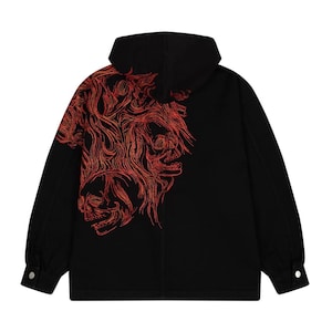 Puede incluir: Chaqueta negra con capucha y diseño de calavera roja bordada en la espalda. La chaqueta tiene puños abotonados y capucha. El diseño de la calavera es detallado, con un patrón en forma de llama.