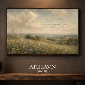 May include: A framed landscape painting featuring a rolling meadow with wildflowers under a cloudy sky. The text reads: The Lord is my light and my salvation - whom shall I fear? The Lord is the stronghold of my life - of whom shall I be afraid? Psalm 27:1.