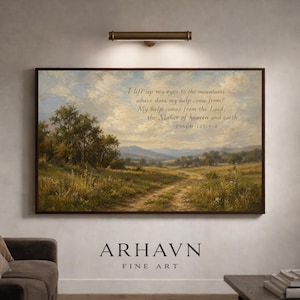 May include: A framed landscape art print featuring a pastoral scene with a dirt path leading towards distant hills under a cloudy sky. The artwork includes the text "I lift up my eyes to the mountains..." and "ARHAVN FINE ART".