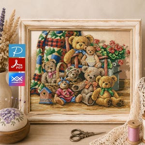 Op de afbeelding: Een ingelijste kruissteek met een groep teddyberen in een gezellige omgeving. De beren zitten in een mand, op een bank en bij een emmer vol bloemen. Het kunstwerk heeft een rustieke, vintage uitstraling, met een houten lijst en zachte kleuren.