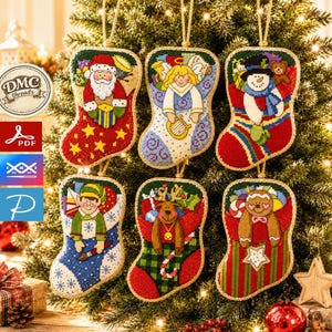 May include: Six cross-stitch Christmas stockings featuring embroidered designs of Santa Claus, an angel, a snowman, an elf, a reindeer, and a gingerbread person. Each stocking is finished with a jute twine loop for hanging on a tree branch.