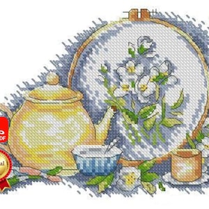 May include: A cross-stitch design featuring a yellow teapot, a teacup, and a floral embroidery hoop with white flowers. The design includes a small teacup and a coaster. The image has a PDF icon and a "Special Gift" badge.